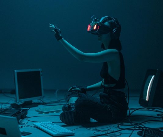 Sanal gerçeklik, teknolojinin gelişimiyle birlikte hayatımıza giren ve gerçek dünyadan tamamen farklı bir deneyim sunan dijital bir ortamdır. Kullanıcıları fiziksel ortamdan izole ederek sanal bir dünyanın içine sokan bu teknoloji, özellikle son yıllarda eğlence, eğitim, sağlık ve savunma gibi pek çok alanda kullanılmaya başlanmıştır. Gerçek dünyaya ait olmayan ancak kullanıcıya tamamen gerçek hissi veren bu ortamlar, özel donanımlar sayesinde üç boyutlu olarak deneyimlenir. Bu sayede kişiler, yalnızca izlemekle kalmaz; aynı zamanda bu dünyaların bir parçası haline gelir. Konulu bir haber görseli.